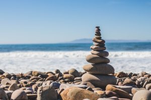 stack of stones on a beach with ocean waves in the background